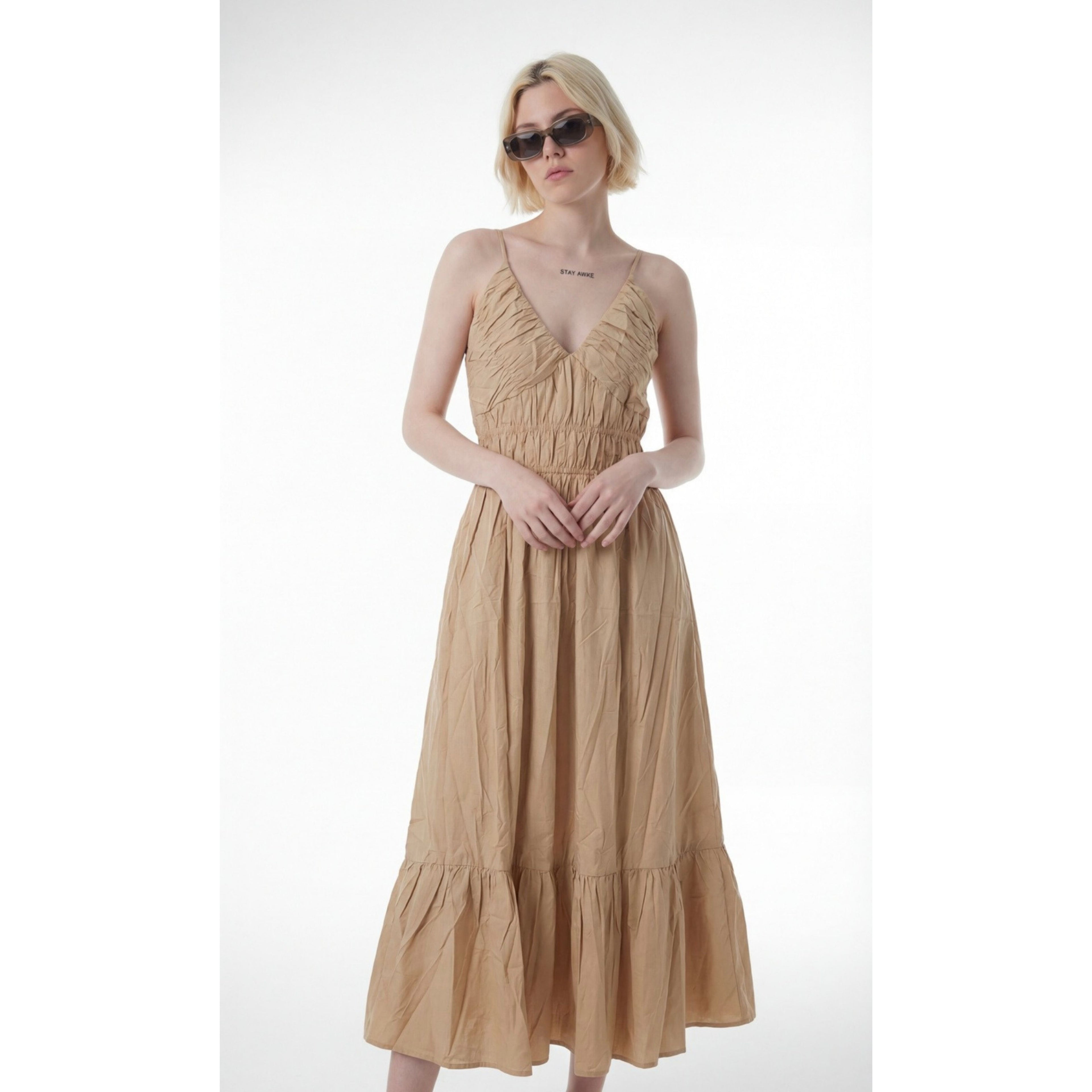 Woman wearing a beige dress on a white background