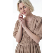 Woman wearing a beige dress on a white background