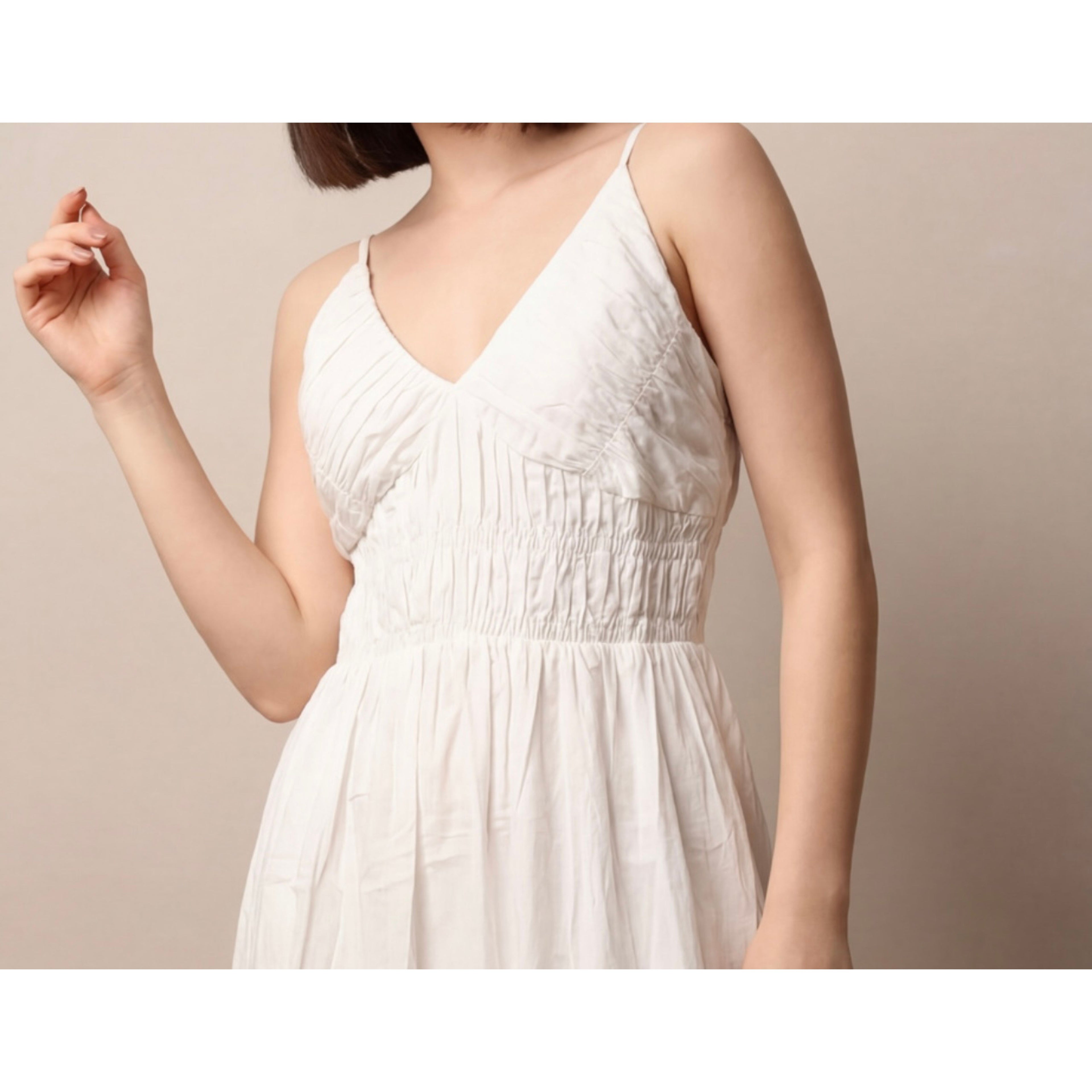 White dress worn by a person on a beige background