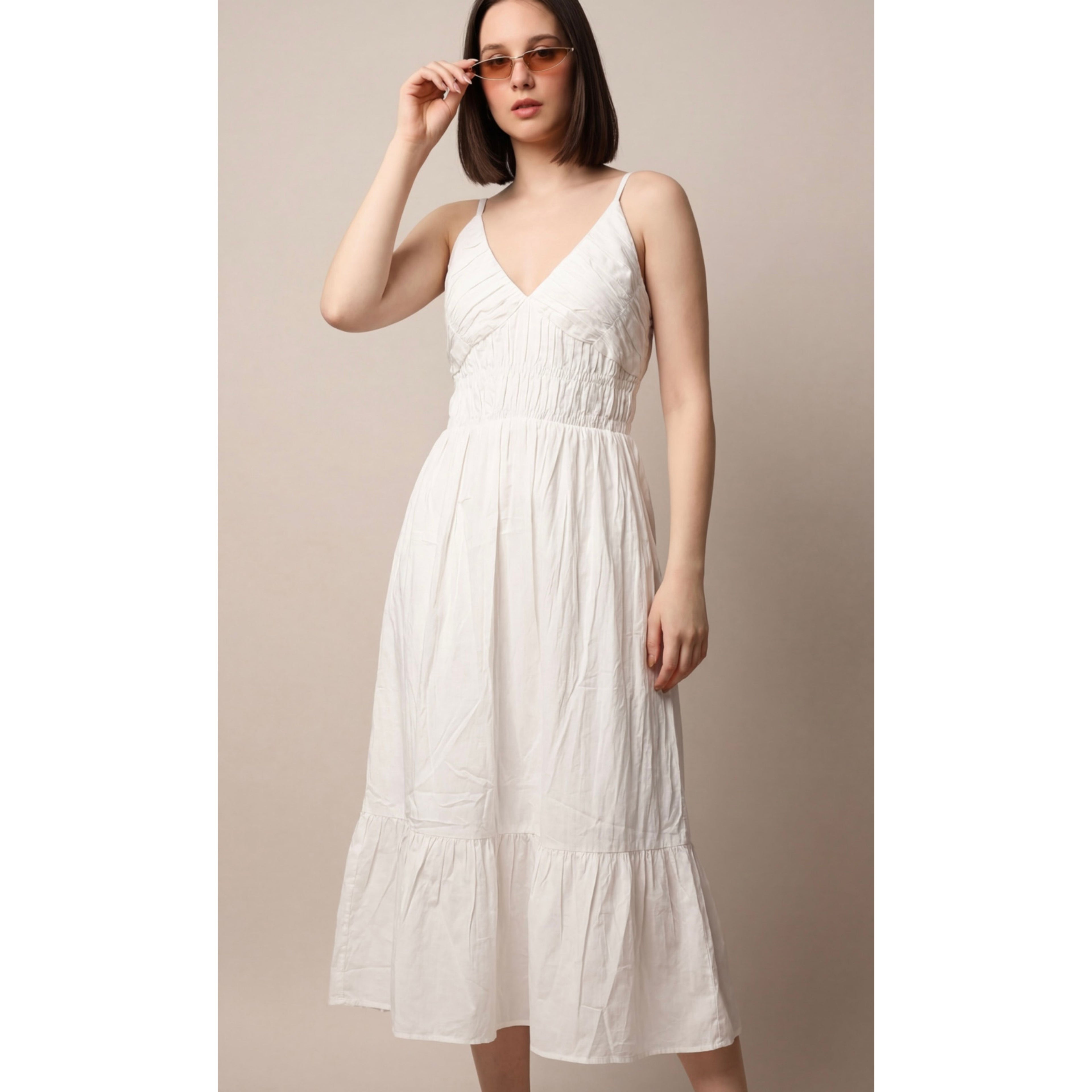 Woman wearing a white dress against a plain background