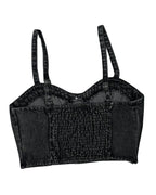Black denim crop top with suspenders on a white background